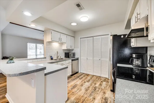 a kitchen with granite countertop a sink stove and refrigerator