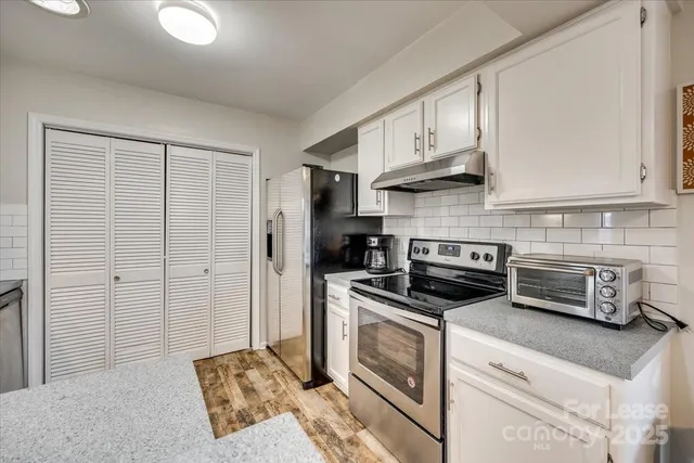 a kitchen with stainless steel appliances granite countertop a stove a refrigerator and a cabinets
