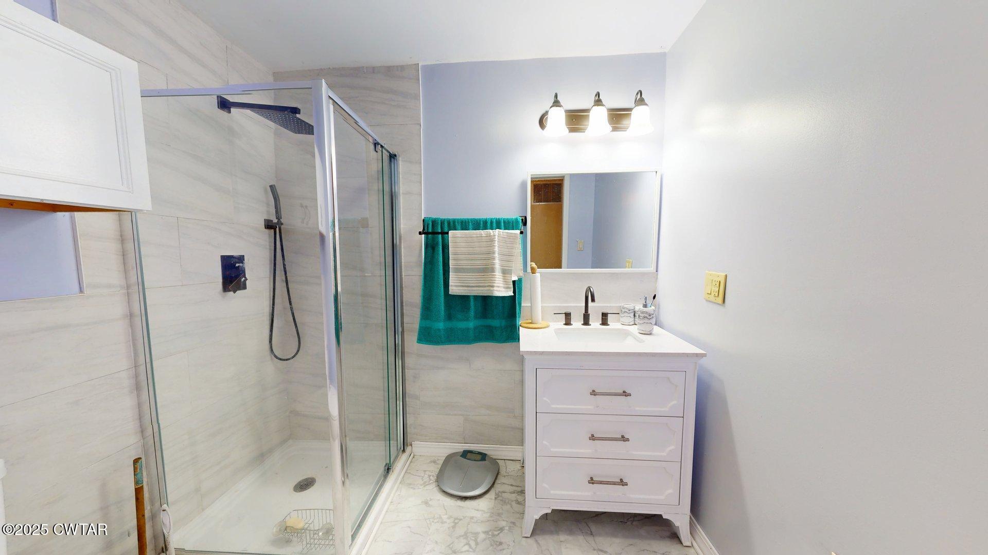 310 North Grayson Street Newbern, TN 38059 - Photo 12 of 22 a bathroom with a shower sink and mirror