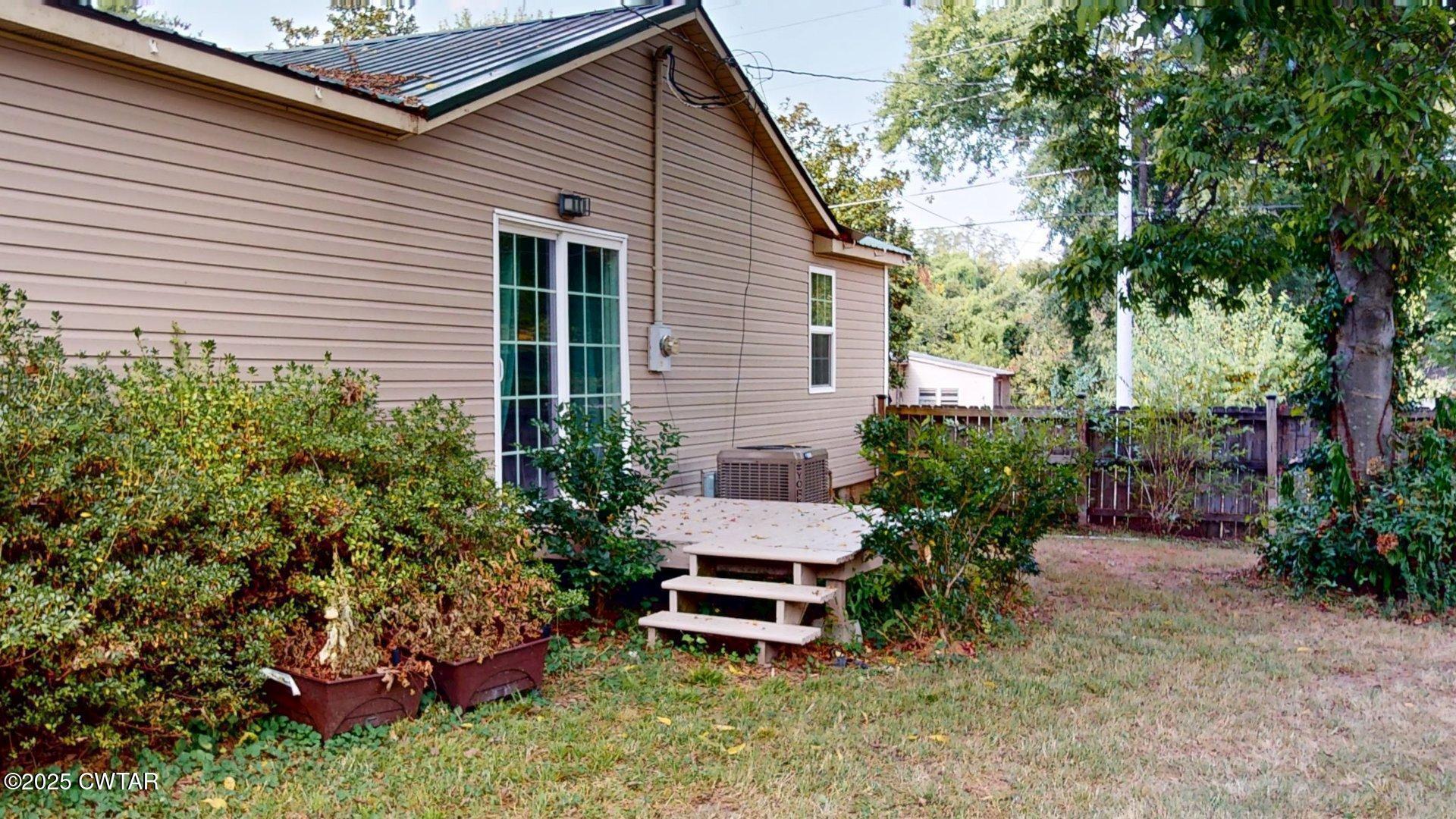 310 North Grayson Street Newbern, TN 38059 - Photo 22 of 22 a wooden bench sitting in front of a house