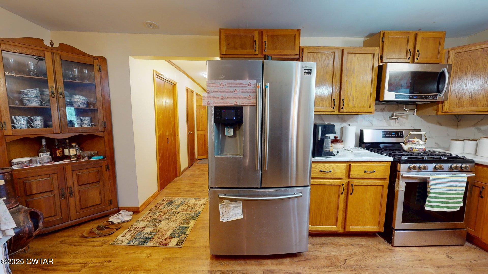 310 North Grayson Street Newbern, TN 38059 - Photo 3 of 22 a kitchen with stainless steel appliances granite countertop a refrigerator a stove top oven a sink and dishwasher