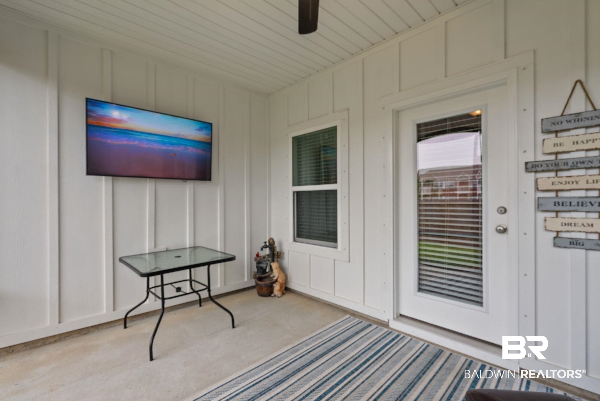9899 Willet Way Foley, AL 36535 - Photo 30 of 37 Covered patio featuring a ceiling fan, white board and batten wall paneling, a full-lite glass panel door, and an operable window