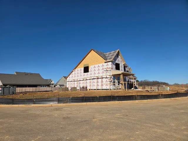 a view of a house next to a road with big yard