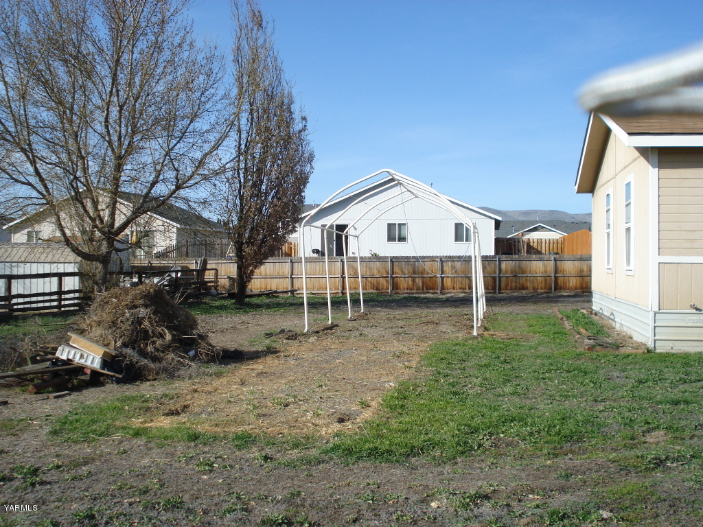 109 Riel Lane Moxee, WA 98936 - Photo 6 of 7 a view of a house with a yard and large trees