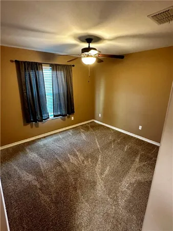 a view of a livingroom with a chandelier fan and windows