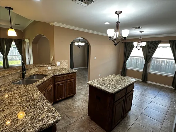 a kitchen with stainless steel appliances granite countertop a stove refrigerator and microwave