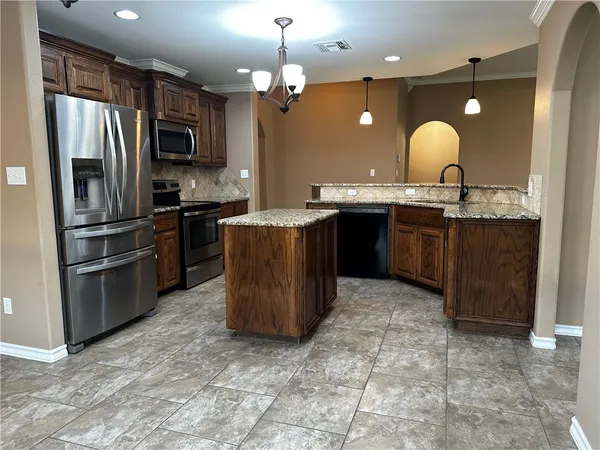 a kitchen with stainless steel appliances granite countertop a refrigerator stove and sink