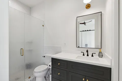 a bathroom with a sink vanity mirror and toilet