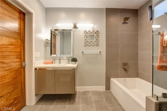 a bathroom with a tub sink and mirror