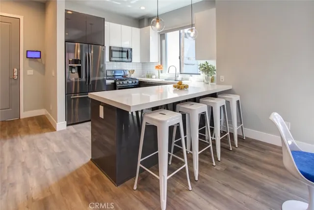 a kitchen with granite countertop a table chairs stove and refrigerator