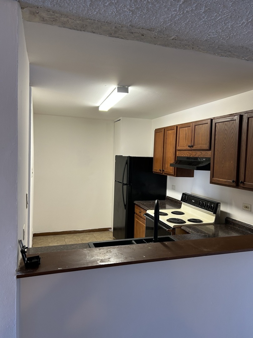 242 George Street, Unit B Bensenville, IL 60106 - Photo 4 of 11 a kitchen with kitchen island granite countertop a sink and a stove top oven