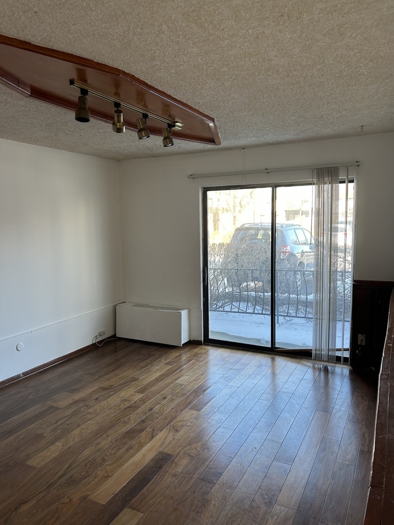 242 George Street, Unit B Bensenville, IL 60106 - Photo 8 of 11 an empty room with wooden floor and windows