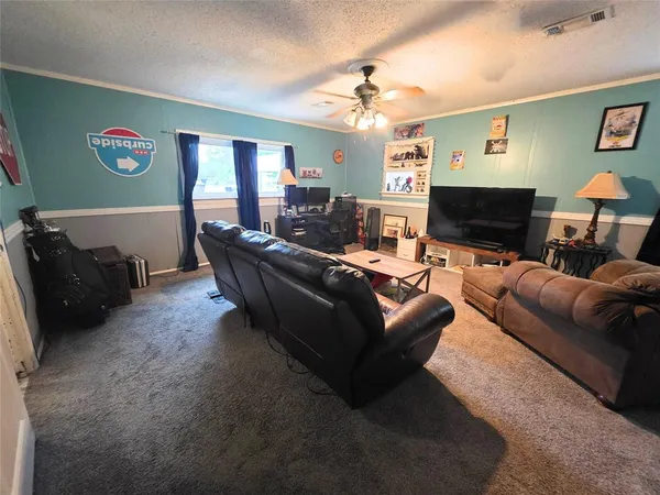 a view of a livingroom with furniture and a ceiling fan