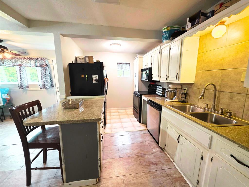 4214 Valview Drive Waco, TX 76708 - Photo 6 of 23 a kitchen with stainless steel appliances kitchen island granite countertop a sink and cabinets