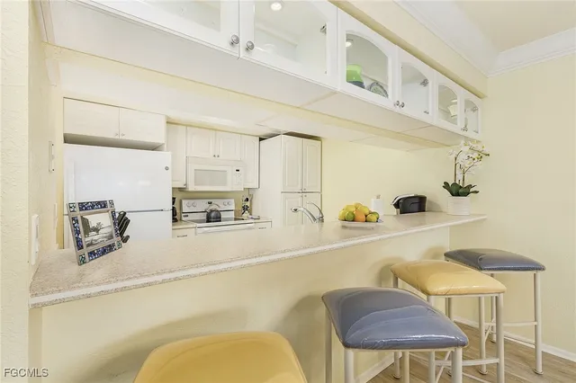 a kitchen with stainless steel appliances kitchen island granite countertop a sink and white cabinets