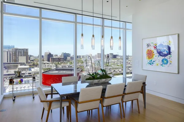 a dining room with furniture and a floor to ceiling window