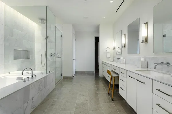 a spacious bathroom with a tub double sink and mirror