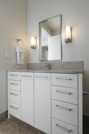 a bathroom with a granite countertop sink vanity and mirror