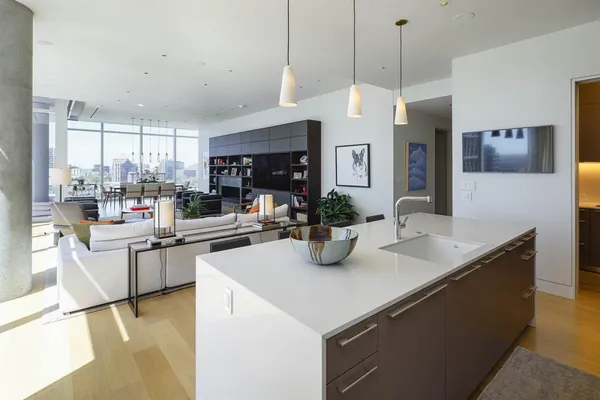 a kitchen with sink cabinets and living room view