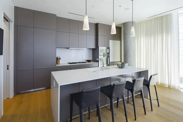 a kitchen with stainless steel appliances a table chairs refrigerator and microwave