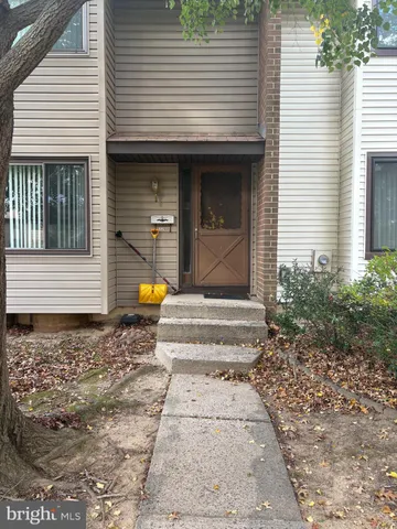 a view of a house with door and wooden bench