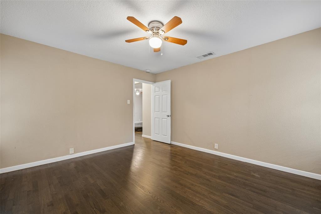 117 Moon Street Cleburne, TX 76033 - Photo 22 of 28 an empty room with wooden floor and ceiling fan