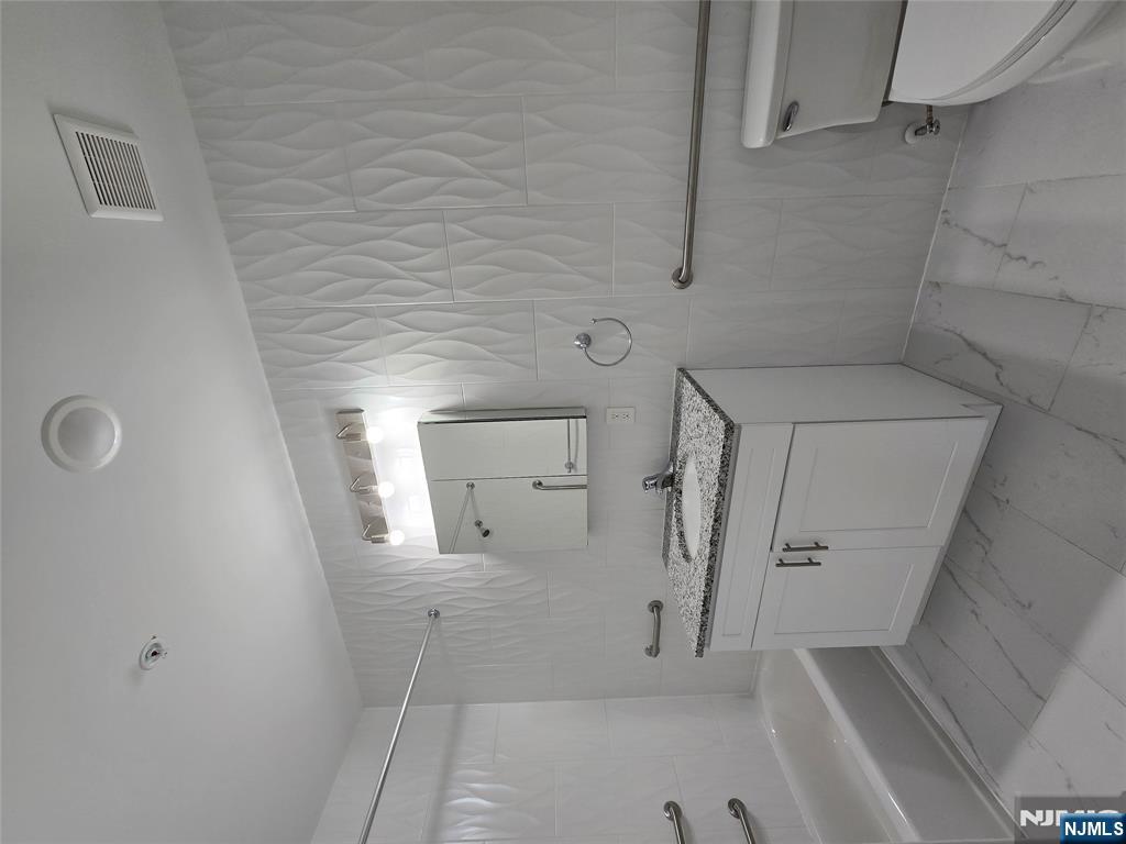 512 Kearny Avenue, Unit 302 Kearny, NJ 07032 - Photo 8 of 13 a bathroom with a granite countertop sink a toilet and bathtub