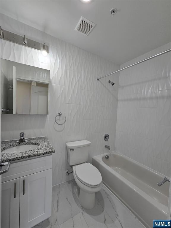 512 Kearny Avenue, Unit 302 Kearny, NJ 07032 - Photo 9 of 13 a bathroom with a granite countertop toilet a sink and bathtub