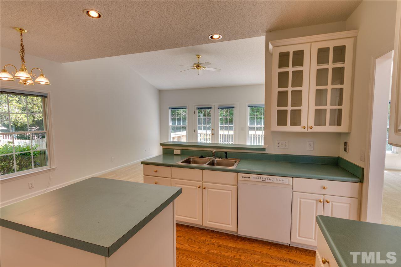 2337 Kendricks Court Raleigh, NC 27613 - Photo 11 of 25 a kitchen with granite countertop a stove a sink and a dishwasher with wooden floor