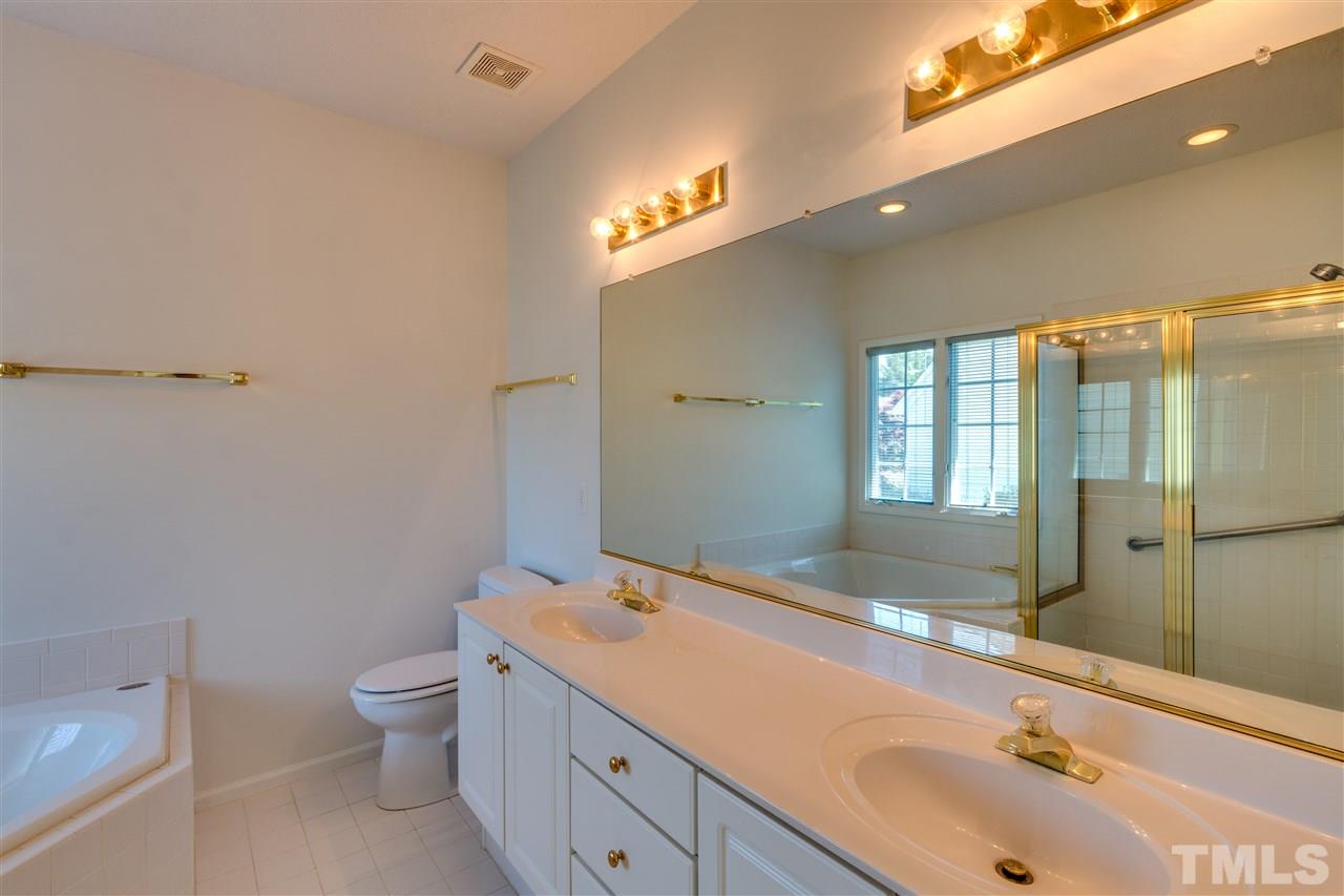 2337 Kendricks Court Raleigh, NC 27613 - Photo 16 of 25 a spacious bathroom with a granite countertop sink a toilet and a tub