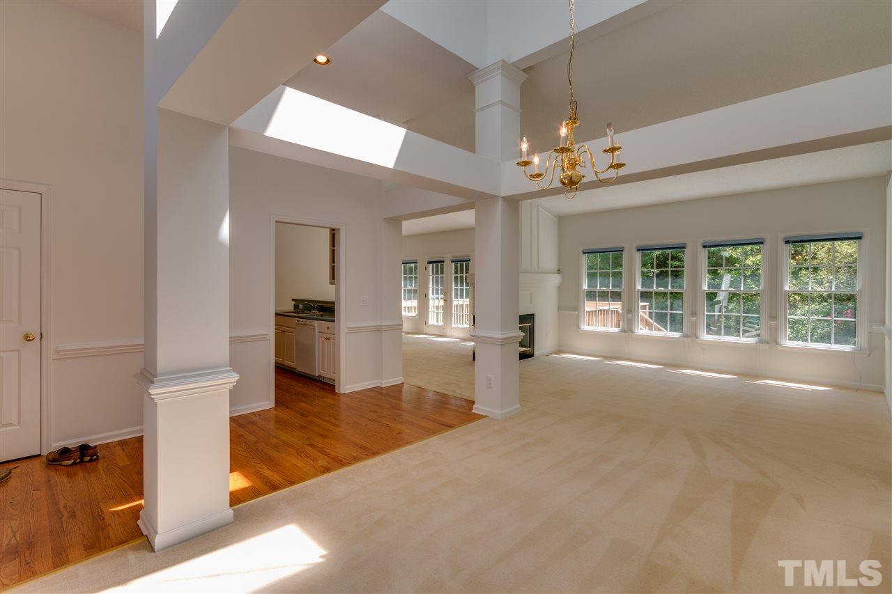 2337 Kendricks Court Raleigh, NC 27613 - Photo 4 of 25 a view of an empty room with wooden floor and a kitchen