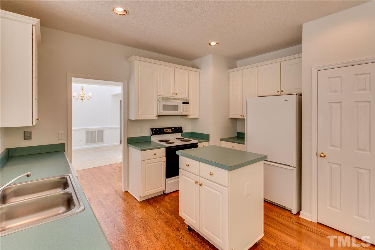 2337 Kendricks Court Raleigh, NC 27613 - Photo 9 of 25 a kitchen with a sink a stove a refrigerator and white cabinets