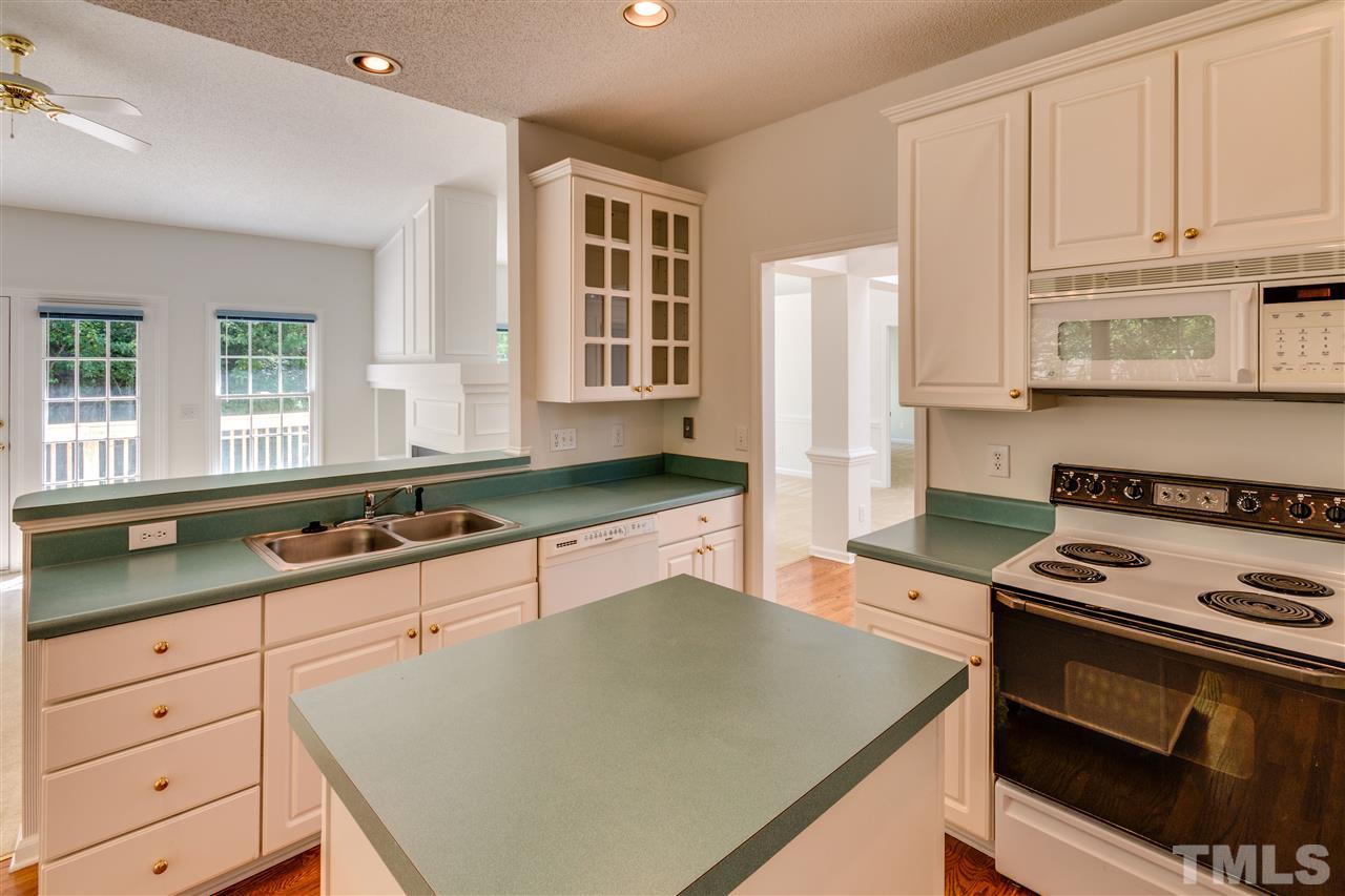 2337 Kendricks Court Raleigh, NC 27613 - Photo 10 of 25 a kitchen with granite countertop a sink stove and cabinets