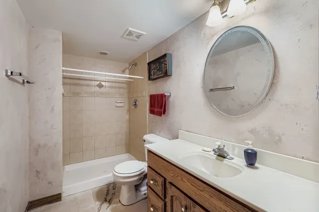 a bathroom with a sink a toilet and shower