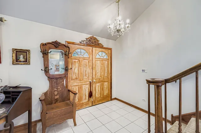a view of a hallway with windows and chandelier
