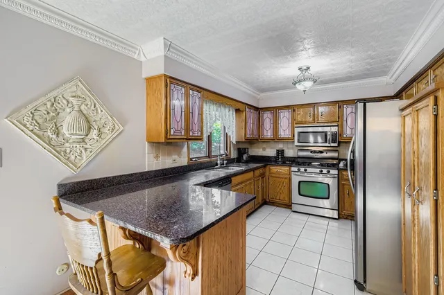 a kitchen with stainless steel appliances granite countertop a sink a stove and refrigerator