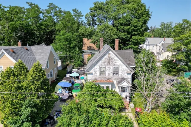 an aerial view of a house with table and chairs and a flower garden