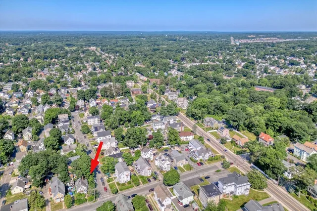 an aerial view of residential houses with outdoor space and trees