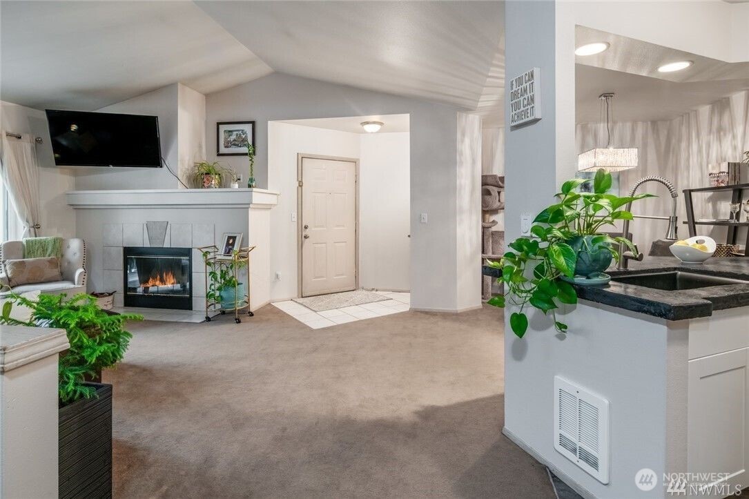 15300 112th Avenue Northeast, Unit B308 Bothell, WA 98011 - Photo 3 of 15 a living room with furniture a fireplace and a flat screen tv