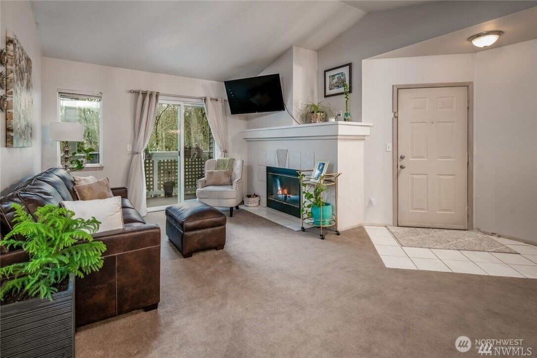 15300 112th Avenue Northeast, Unit B308 Bothell, WA 98011 - Photo 4 of 15 a living room with furniture a fireplace and a flat screen tv