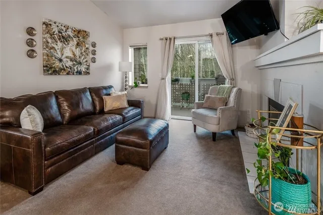 a living room with furniture a flat screen tv and a floor to ceiling window