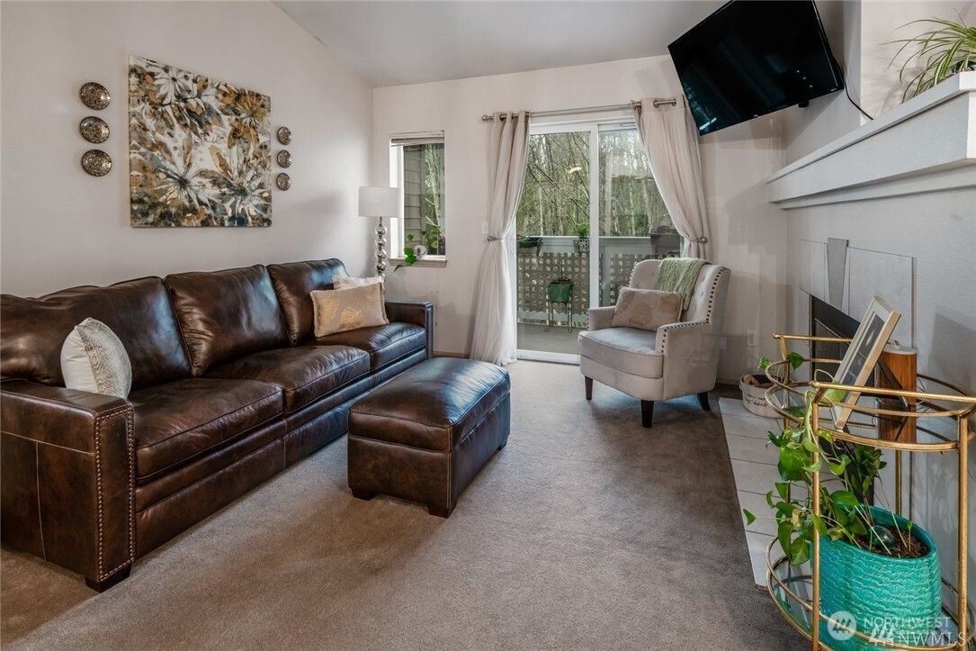 15300 112th Avenue Northeast, Unit B308 Bothell, WA 98011 - Photo 5 of 15 a living room with furniture a flat screen tv and a floor to ceiling window