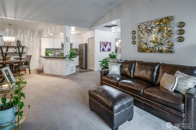 a living room with furniture a couch and kitchen view