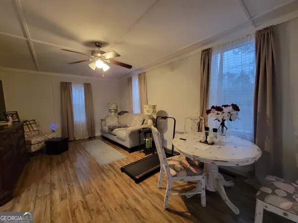 a view of a dining room with furniture a chandelier and wooden floor