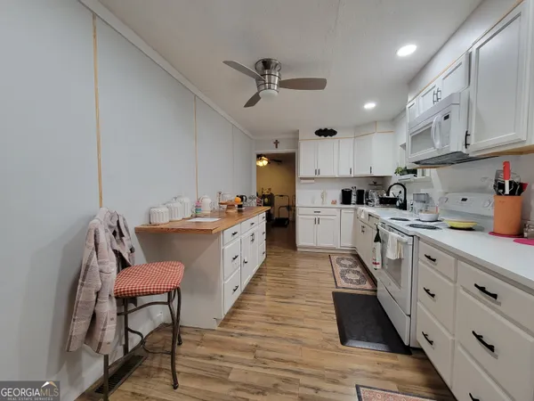 a open kitchen with stainless steel appliances granite countertop a sink dishwasher a stove refrigerator and cabinets with wooden floor