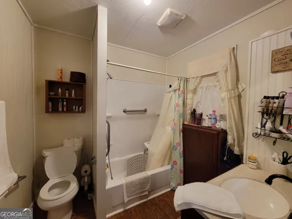 a white toilet sitting next to a bathroom sink and a shower