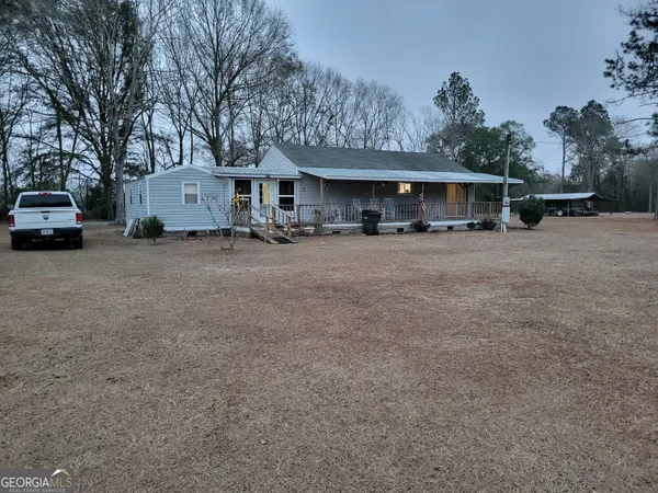 a view of a house with a yard and sitting area