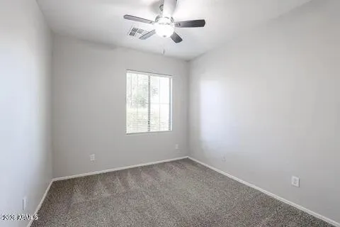 an empty room with a window and a fan