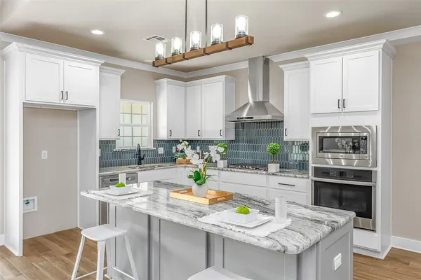 a kitchen with stainless steel appliances granite countertop a stove top oven a sink a stove and white cabinets