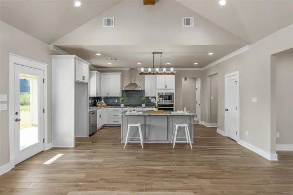 a large white kitchen with lots of counter space and stainless steel appliances